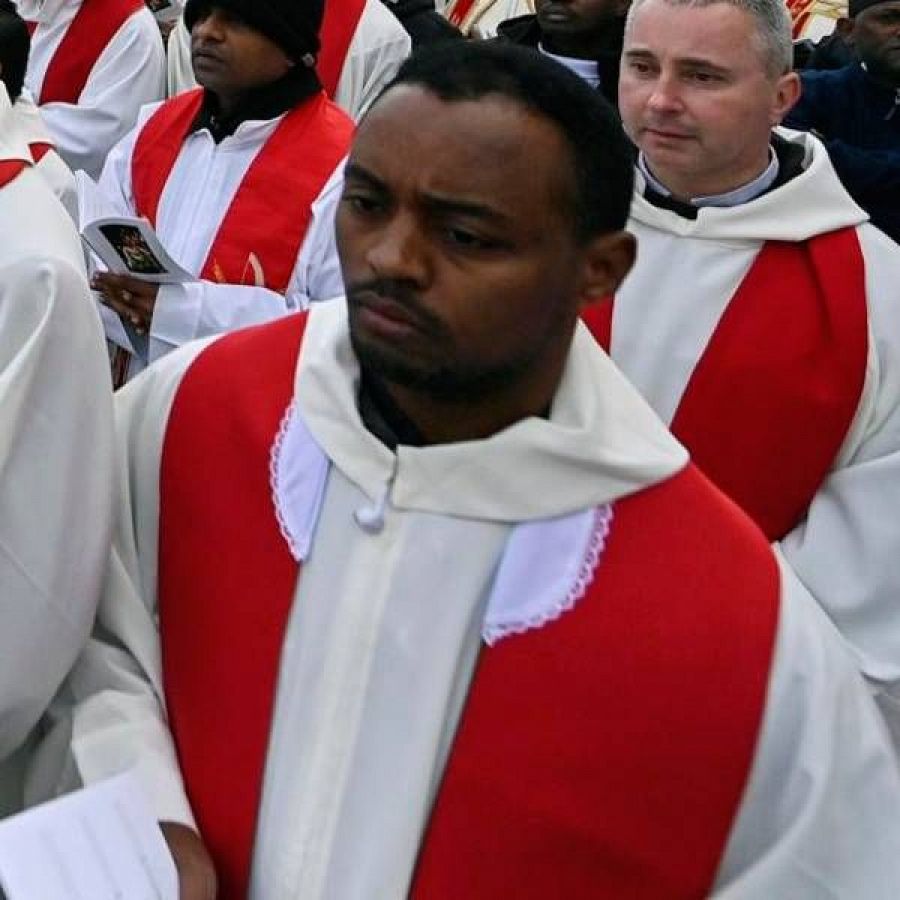 Un sacerdote vistiendo casulla blanca y estola roja.
