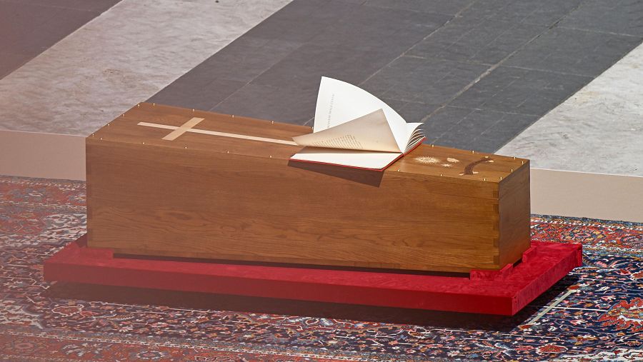Las hojas del Evangelio movidas por el viento sobre el ataúd del papa Francisco.
