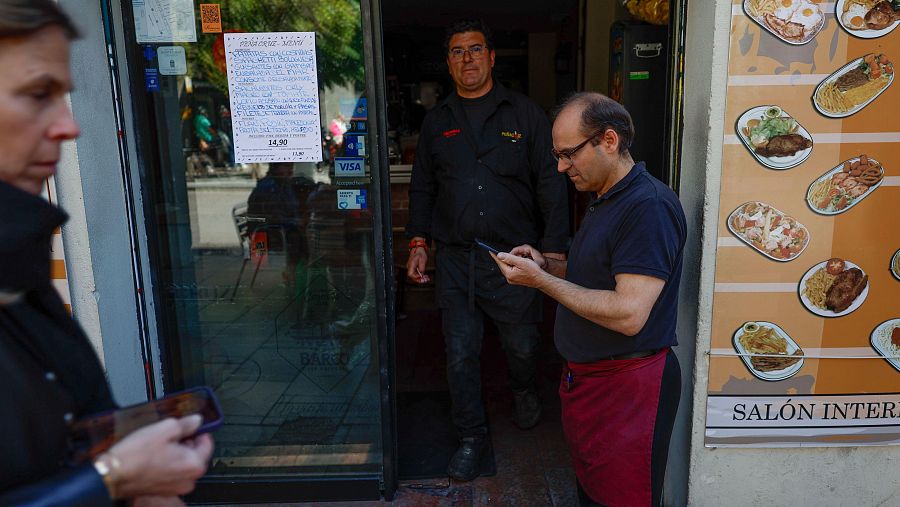 Camareros y clientes de un bar de Madrid comprueban la conexión tras el apagón