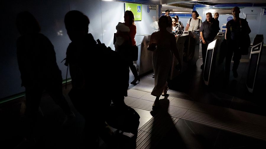 Usuarios del Metro de Madrid abandonan una de las estaciones del suburbano tras registrarse un apagón a nivel peninsular este lunes.