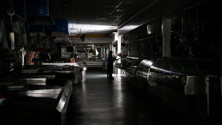 Un hombre y un niño caminan por un mercado local durante un apagón masivo en Vigo, noroeste de España, el 28 de abril de 2025.