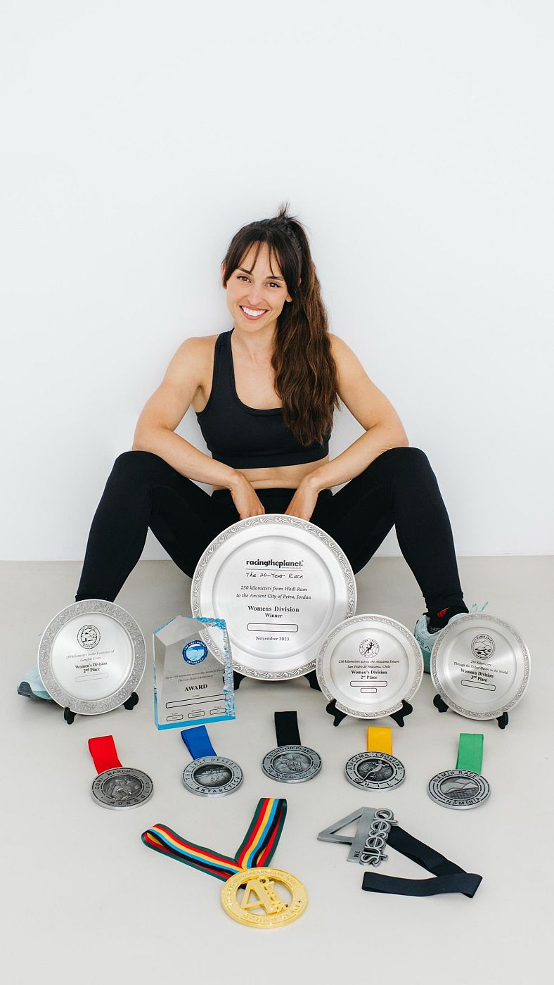 Ganadora de carrera posa con premios: gran plato con inscripción 