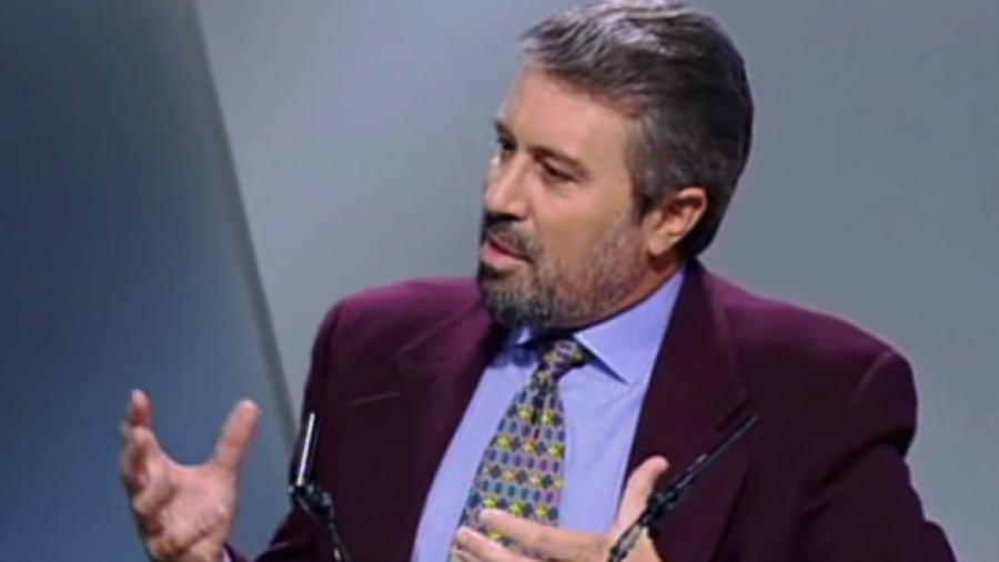 Iñaki Gabilondo, con americana granate y corbata estampada, habla en una entrevista o programa de televisión. Dos micrófonos y el texto 