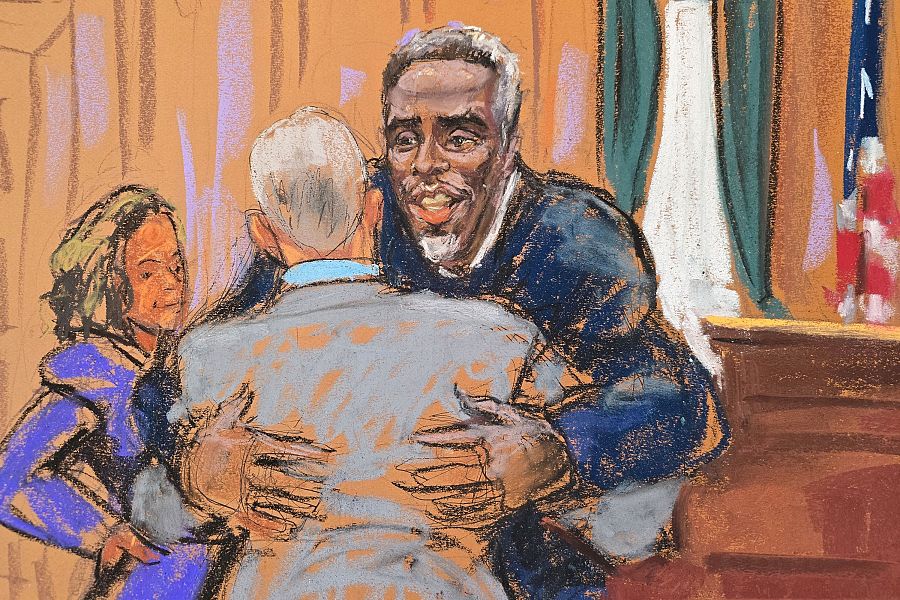 Sean Combs abraza a su abogado en una sala de tribunal; una mujer observa; la escena sugiere alivio o celebración.