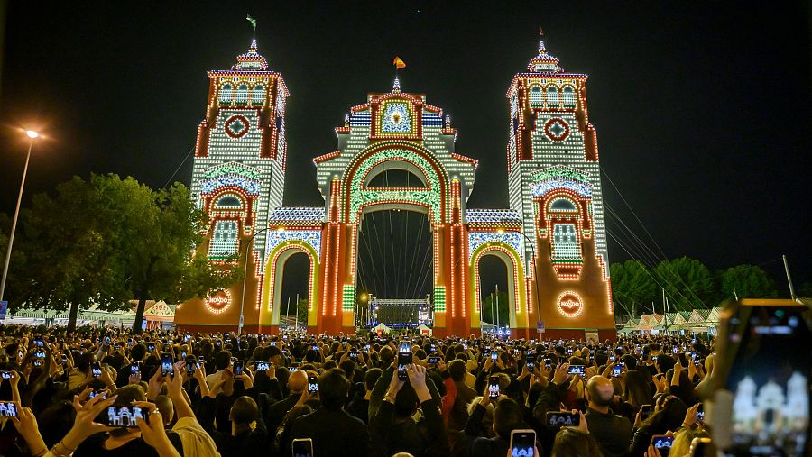 Una multitud de personas presencia el encendido de la portada de la Feria de Abril 2025, Sevilla