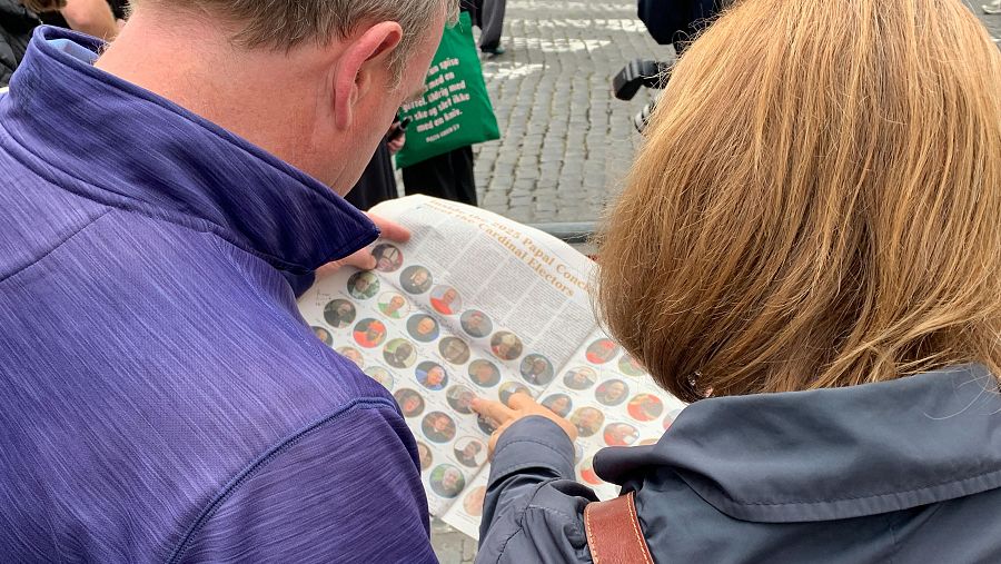 Michael Kilmartin (i) enseña sus anotaciones sobre cardenales en una hoja de periódico