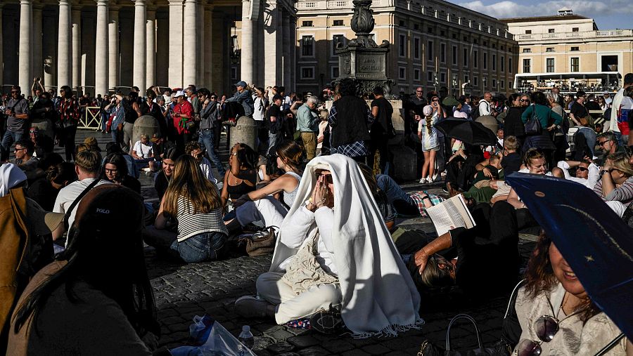 Una mujer reza mientras los fieles se reúnen en la Plaza de San Pedro