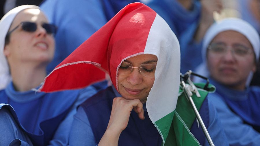 Una monja se cubre la cabeza con una bandera de Italia