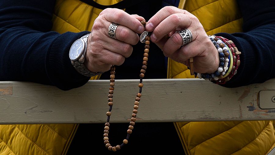 Un católico reza el rosario mientras espera la 'fumata' de la tarde del jueves