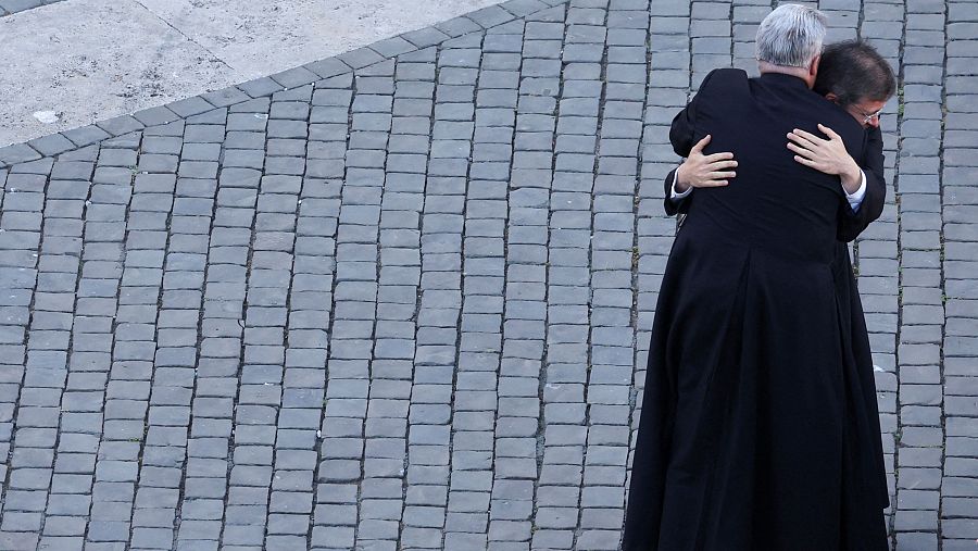 Sacerdotes se abrazan ante el humo blanco de la chimenea de la Capilla Sixtina