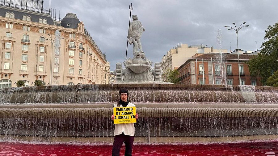 Greenpeace tiñe de rojo el agua de la fuente de Neptuno en Madrid para exigir un embargo de armas a Israel
