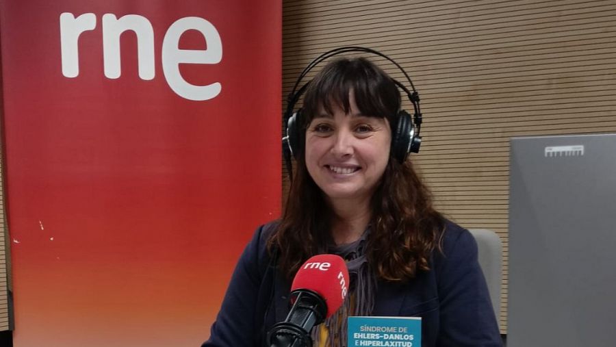 Presentadora de RNE en estudio de radio, con auriculares, hablando a micrófono sobre 
