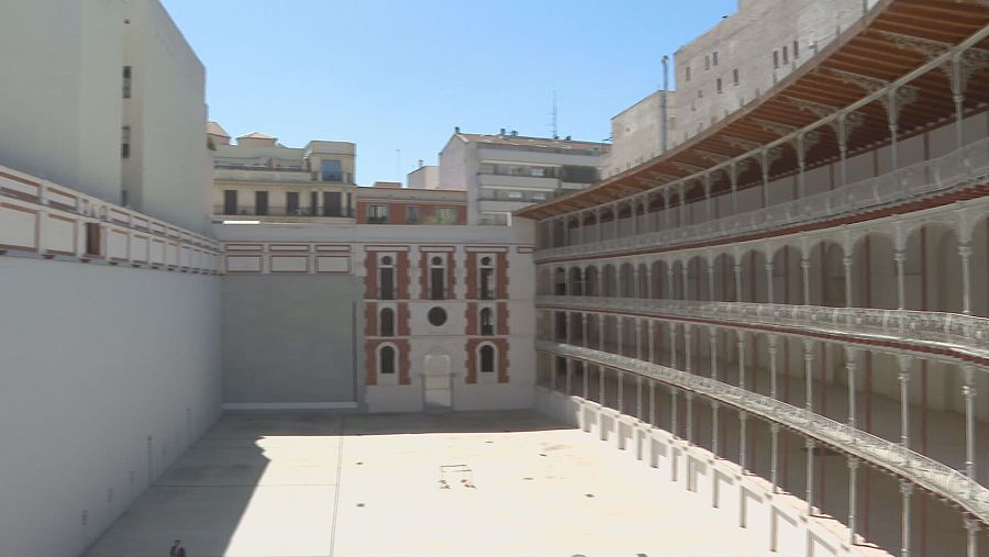 Imagen interior del frontón Beti Jai restaurado: cancha central, galerías con barandillas blancas y una estructura rectangular blanca en un extremo.  Amplitud y arquitectura histórica.