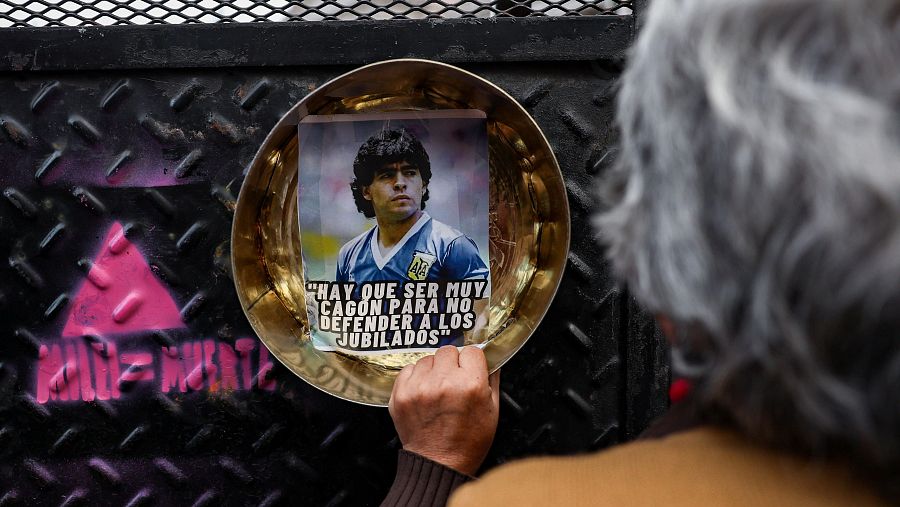 Un jubilado golpea una barricada con una plancha de metal durante una protesta.