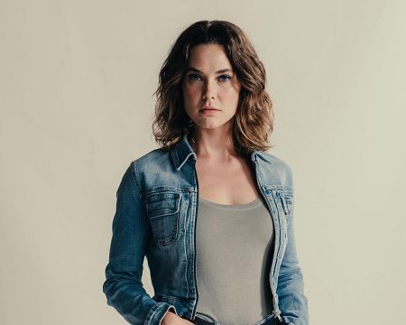 Mujer con chaqueta vaquera y camiseta gris, mirada seria, pelo castaño corto y ondulado.  Texto: 