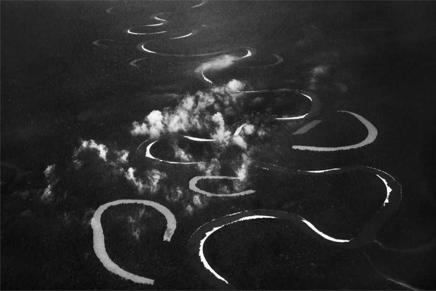Vista aérea del río Jutaí en la Amazonía brasileña.  El río, de color claro, serpentea a través de la densa vegetación oscura, creando un fuerte contraste.