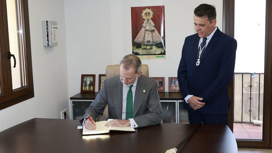 Felipe VI durante su firma en el libro de honor de la localidad