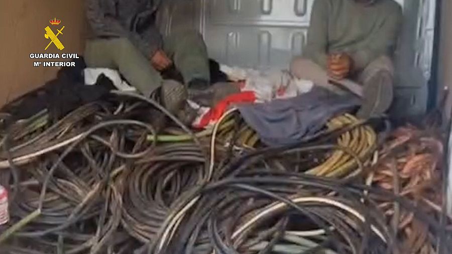 Detenidos sentados entre numerosos cables de distintos colores y grosores en el interior de una furgoneta.  Posible incautación policial.