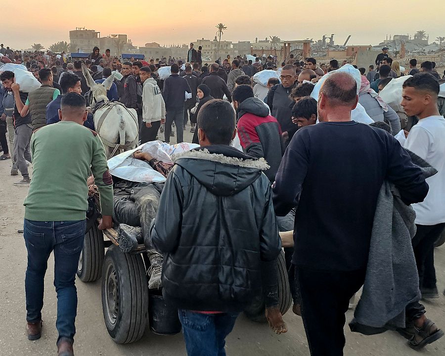 Palestinos desplazados empujan un carro con cadáveres tras ser alcanzados por disparos israelíes cuando se dirigían a un centro de distribución de alimentos en Ráfah