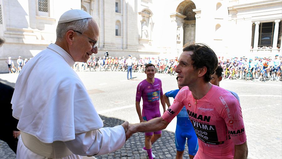El Papa Francisco estrecha la mano de Simon Yates, líder del Giro de Italia (maglia rosa), en presencia de otros ciclistas.