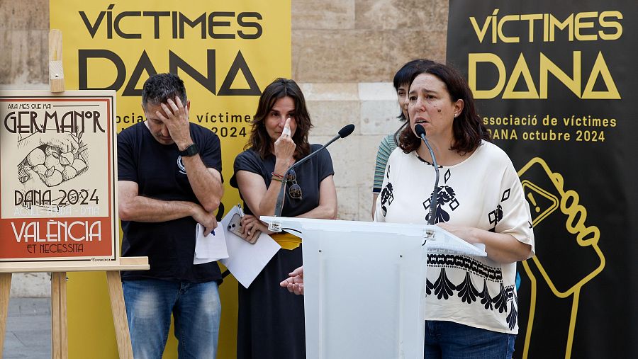 Conmovedor acto público por las víctimas de la DANA de octubre de 2024 en Valencia.  Se aprecian pancartas con mensajes de apoyo y personas visiblemente afectadas.
