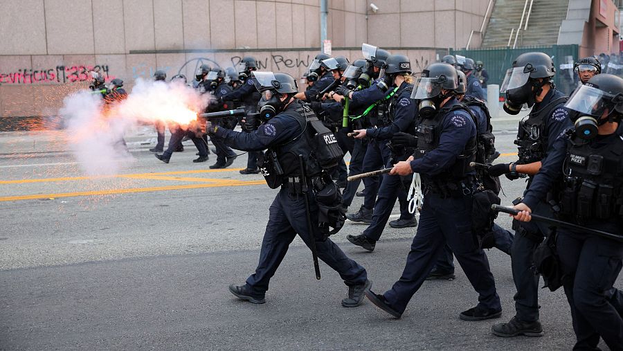 Un agente de policía utiliza granadas aturdidoras mientras se acercan a los manifestantes congregados en torno al Edificio Federal de Los Ángeles