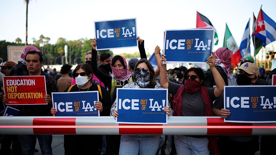 Manifestantes sostienen pancartas mientras se reúnen en torno al Edificio Federal de Los Ángeles tras las múltiples detenciones
