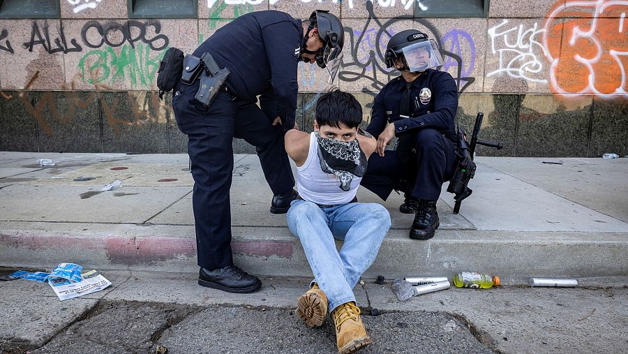 Policías detienen a un manifestante durante una protesta contra las redadas federales de inmigración en Los Ángeles