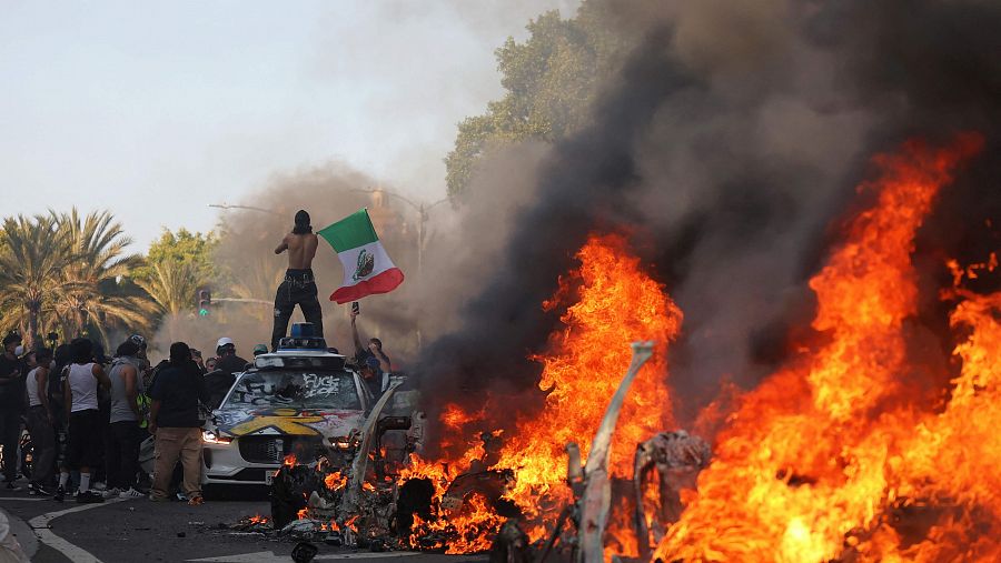 Varios vehículos en llamas durante una protesta contra las redadas masivas de migrantes en Los Ángeles