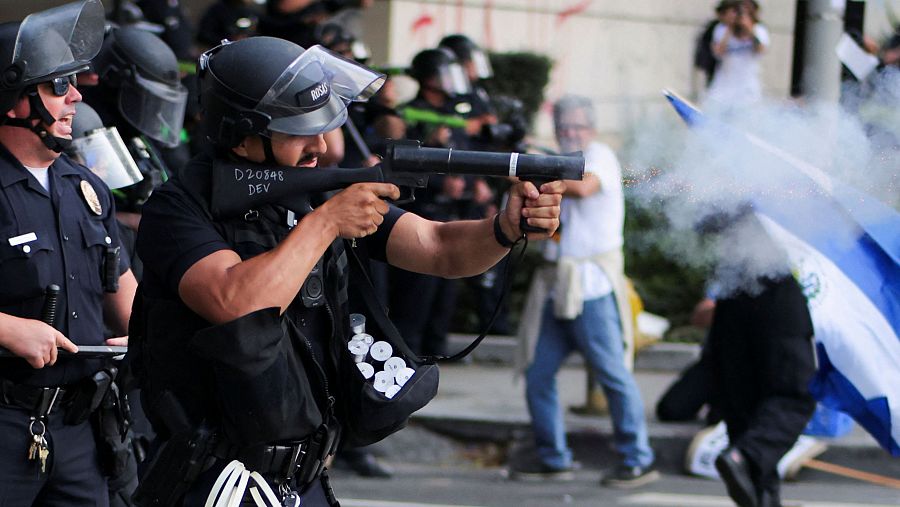 Un policía dispara municiones de control de multitudes durante una protesta en Los Ángeles