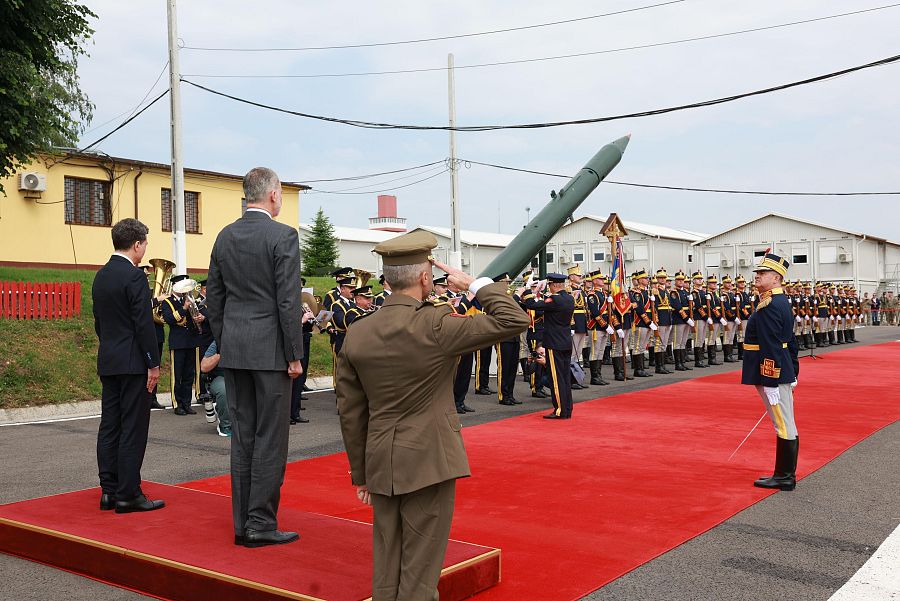 Visita oficial a base militar: Felipe VI y el presidente rumano observan una formación militar durante un acto protocolario.