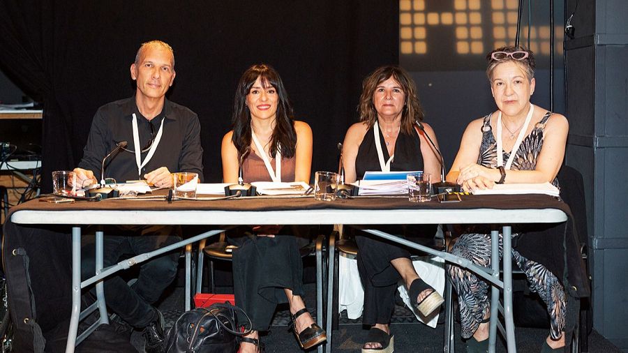 El jurat David Bassa, Alicia Gómez, Gemma Gallent i Joana Ballès asseguts a una taula amb cadires.