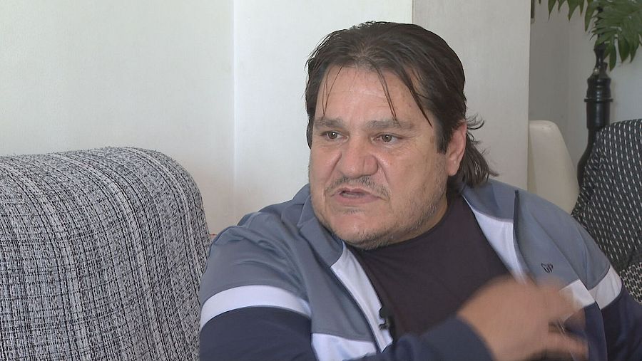 Entrevista a un hombre en interior; lleva chaqueta azul marino.  Texto superpuesto: 