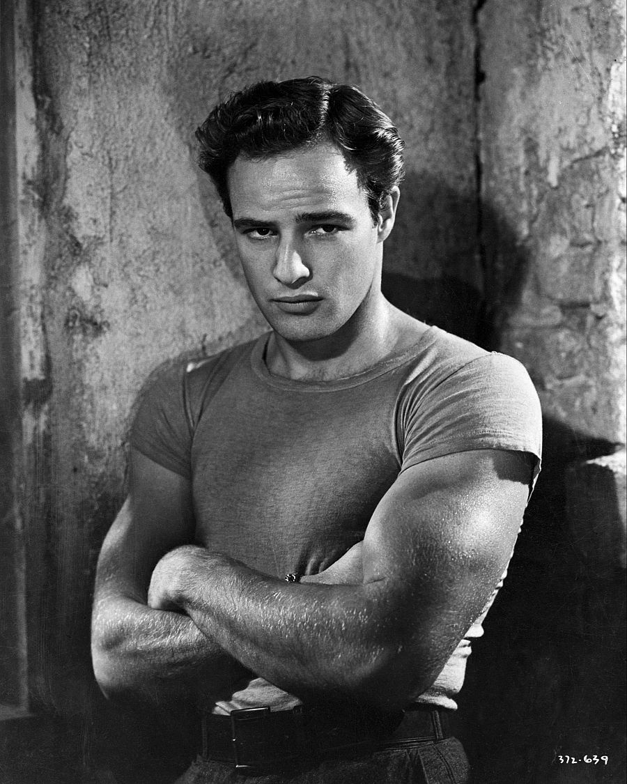 Marlon Brando, en blanco y negro, interpreta a Stanley Kowalski.  Cabello corto, camiseta ajustada y expresión seria.