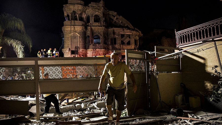 Un hombre camina tras el impacto de misiles lanzados desde Irán sobre un edificio residencial en el norte de Israel, en Tamra, Israel.