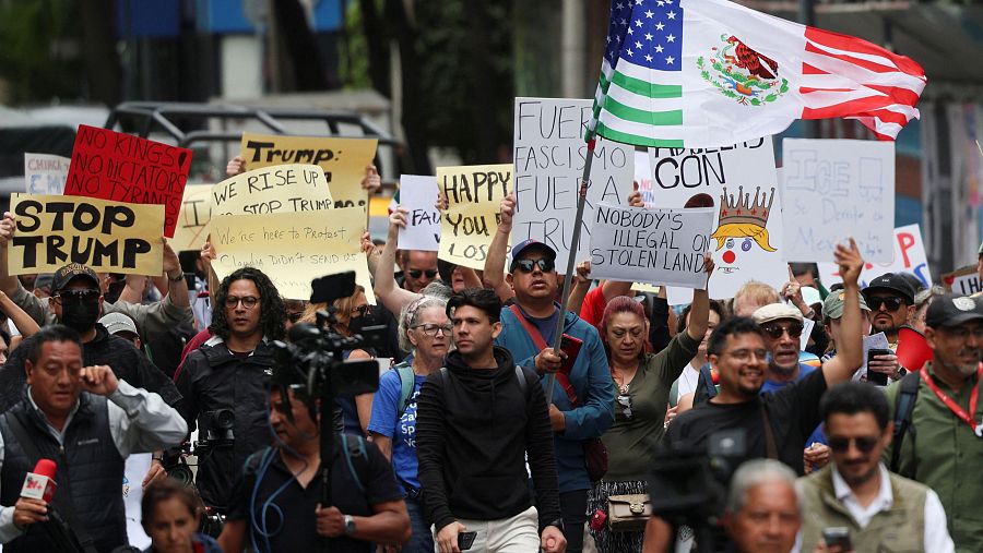 Manifestantes sostienen carteles y una bandera durante la protesta del Día Sin Reyes contra las políticas del presidente de EE. UU., Donald Trump, en la Ciudad de México, México, 14 de junio de 2025. REUTERS/Luis Cortes