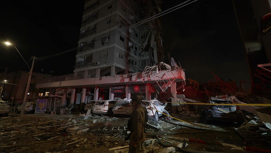 Equipos de rescate israelíes trabajan en el lugar donde misiles balísticos iraníes impactaron edificios residenciales en Bat Yam, cerca de Tel Aviv,