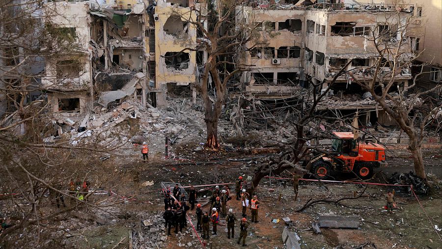 Rescatistas se encuentran entre los escombros de un edificio dañado en la ciudad israelí de Tel Aviv