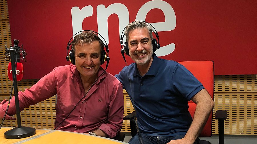 Grabación en estudio de RNE: Antonio Montero, con camisa rosa, y otro hombre con camisa azul marino, participan en una entrevista o programa de radio.  Micrófono y logo de RNE visibles.
