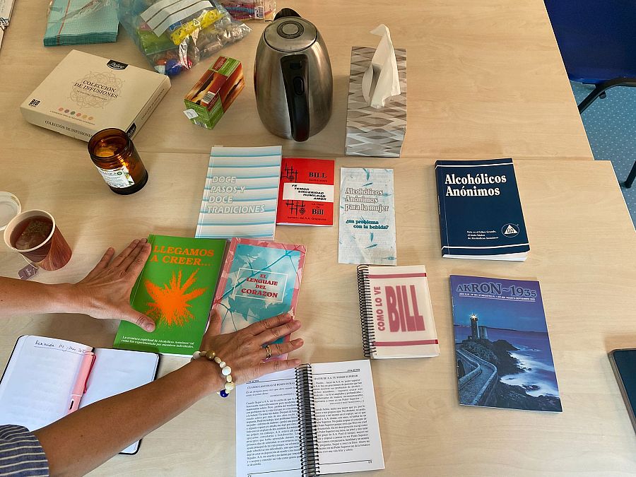 Literatura, clínex, vela e infusiones para la sesión presencial de alcohólicas anónimas.
