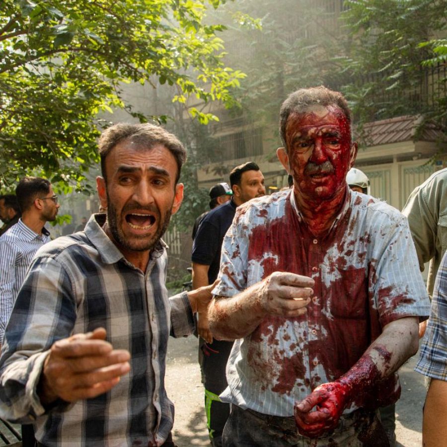 Iraníes atienden a un hombre herido tras un ataque en el centro de Teherán
