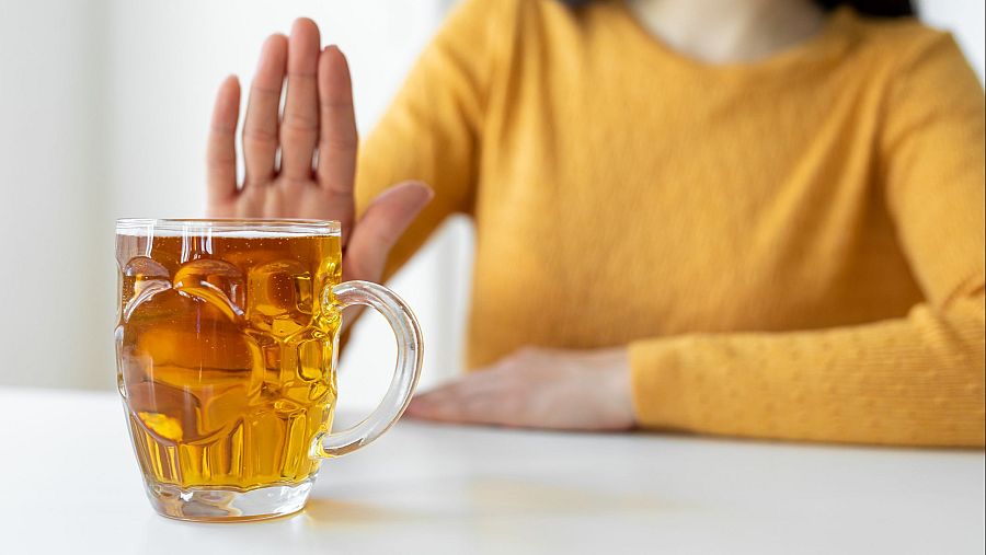 Mano rechazando jarra de cerveza; campaña contra el consumo excesivo de alcohol.