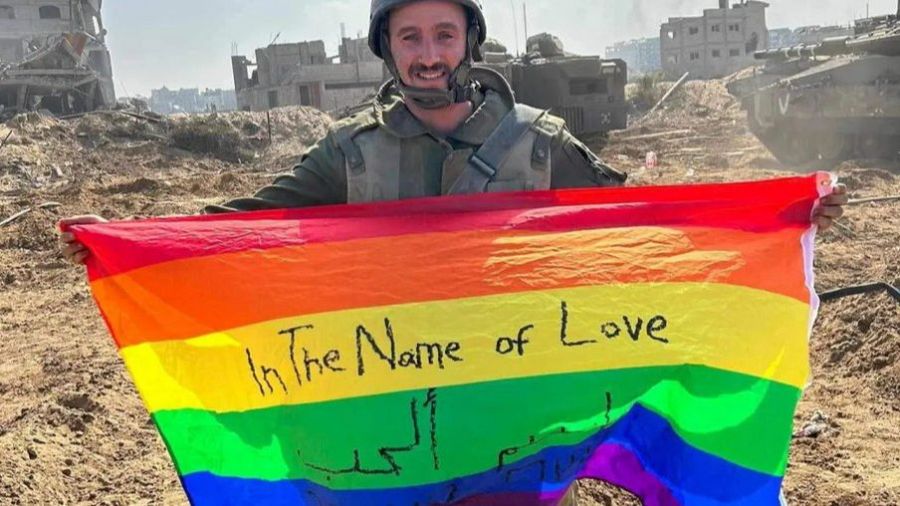 El soldado israelí Yoav Atzmoni sostiene una bandera arcoíris con la inscripción 