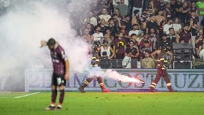 Varios bomberos recogen bengalas del campo durante el Salernitana-Sampdoria