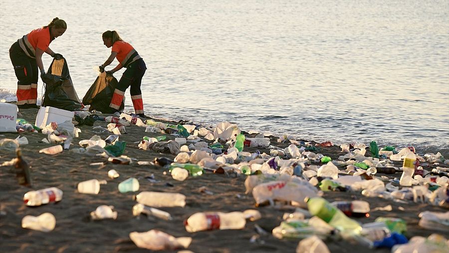 Servicios de limpieza y miembros de la Policía Nacional en la playa de la Malagueta en 2024