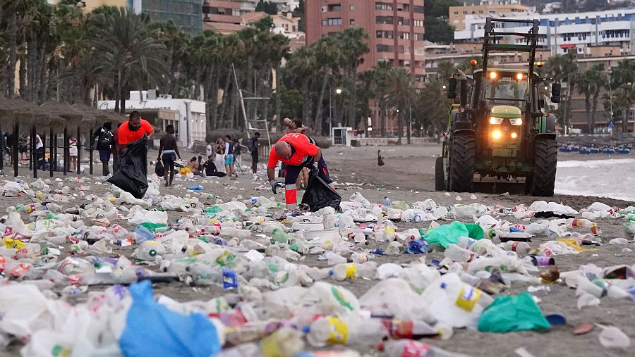 Miembros del servicio de limpieza municipal de Malaga recogen restos de basura en la playa
