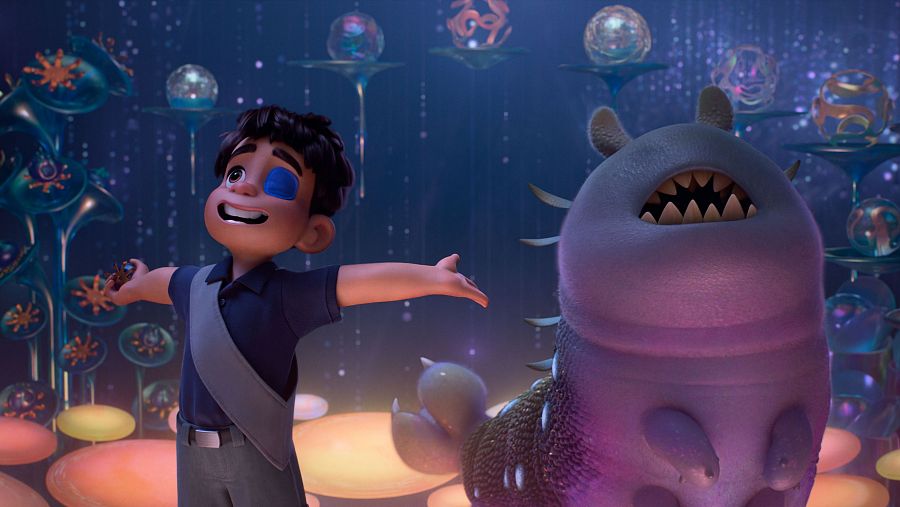 Un niño con parche en el ojo y una criatura alienígena púrpura interactúan en un entorno extraño y brillante, fotograma de una película animada.