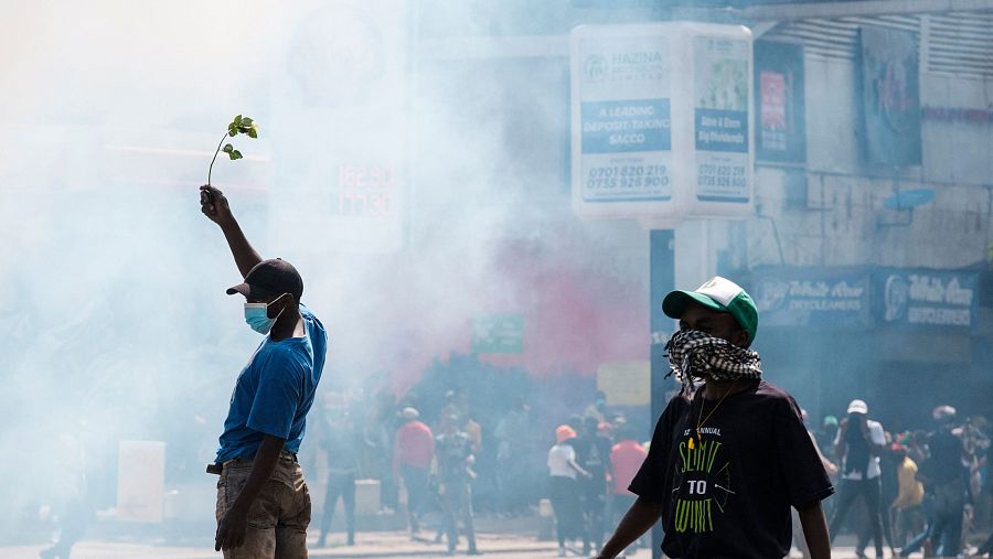 Un manifestante sostiene una rosa mientras le envuelve una nube de gas lacrimógeno en el centro de Nairobi