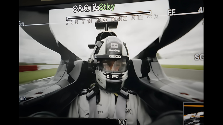 Imagen desde la cabina de un monoplaza F1, mostrando a un piloto con casco y traje. Se ven detalles técnicos de grabación y parte del circuito.