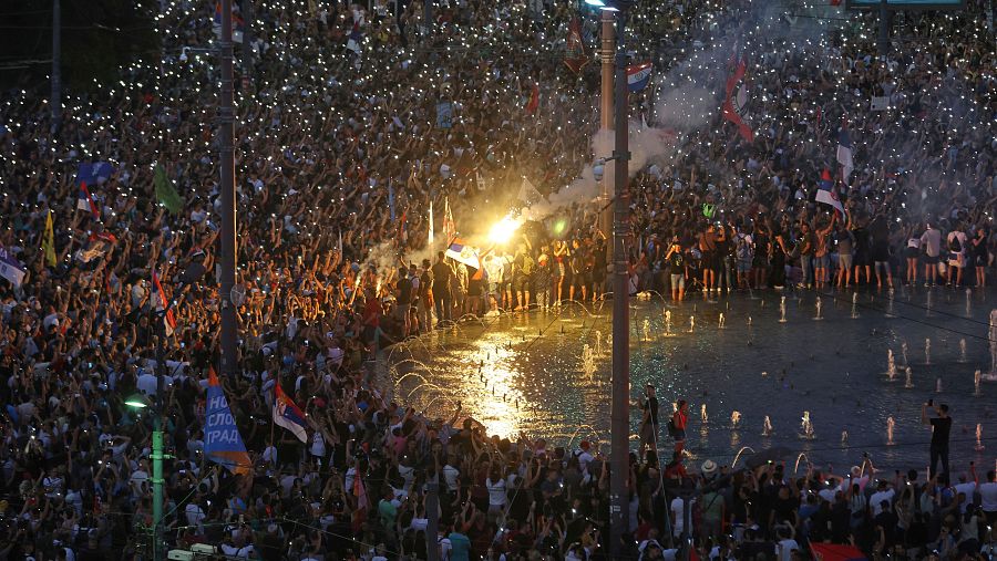 Varias personas agitan sus teléfonos móviles con luces intermitentes durante una gran concentración antigubernamental en Belgrado